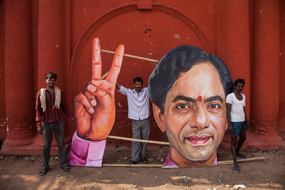 Workers deconstruct an image after the signing-in ceremony of the Chief Minister of India's newest state