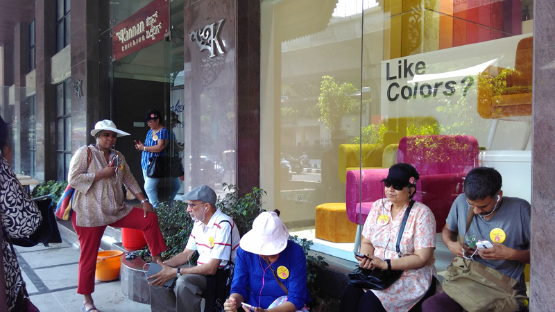 Walk participants pause to hear the audio clips of Bangaloreans talking about the Kannan Building